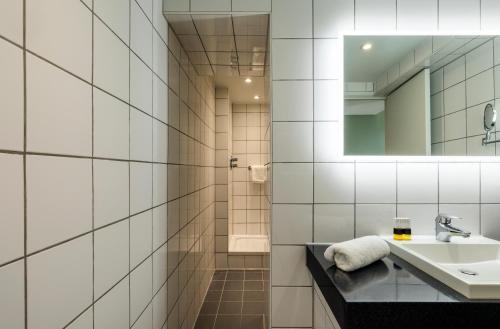 a bathroom with a sink and a mirror at Mercure Bedford Centre Hotel in Bedford