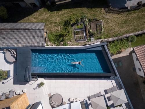een uitzicht op een persoon die in een zwembad zwemt bij Alpin & Stylehotel Die Sonne in Parcines