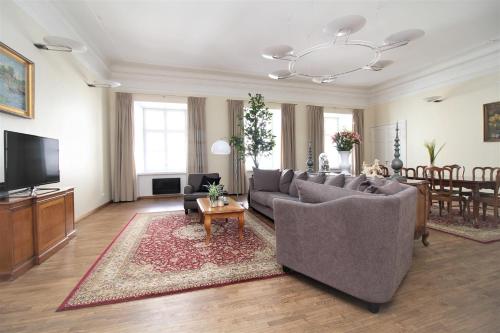 a living room with a couch and a tv and a table at Tallinn City Apartments Old Town Toompea in Tallinn