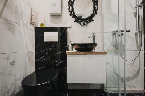 ein schwarzweißes Bad mit einem Waschbecken und einem Spiegel in der Unterkunft ZEUS Design Apartments Lovely Home Vienna in Wien