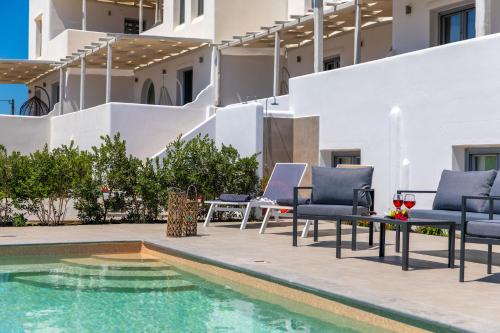 a pool with lounge chairs next to a building at Salinus Beachfront Private Pool Villas in Plaka