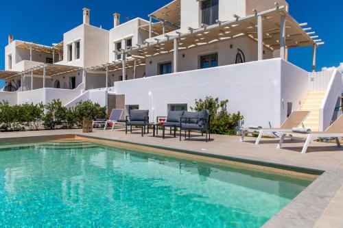 a villa with a swimming pool in front of a house at Salinus Beachfront Private Pool Villas in Plaka