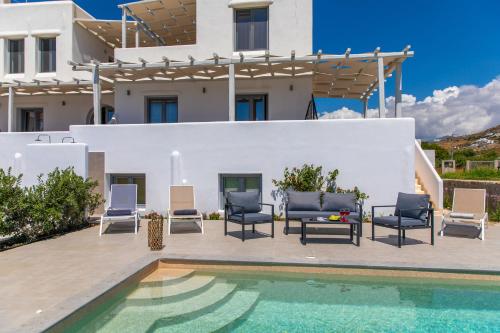 a villa with a swimming pool and a house at Salinus Beachfront Private Pool Villas in Plaka