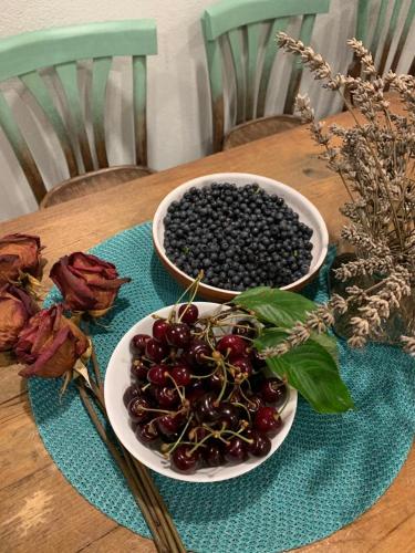 a plate of cherries on a table with a bowl of berries at Il mulino di Aurora in Dosso del Liro