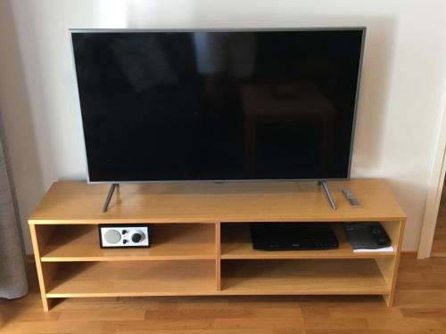 a flat screen tv on a wooden tv stand at Premium Chalet 4109 Blue in Vierumäki