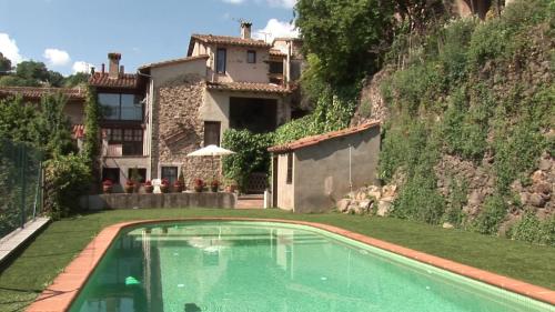 a swimming pool in front of a house at Allotjaments Rurals Can Pere Petit in Santa Pau