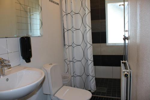 a bathroom with a sink and a toilet and a shower at Sjövillan Bed & Breakfast in Sandöverken