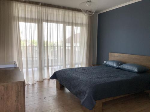1 dormitorio con cama y ventana grande en Sezon, en Svityazʼ
