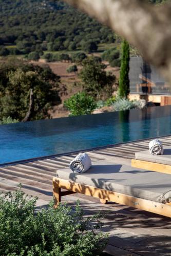 a wooden deck with a view of a body of water at Hôtel Restaurant Villa Joséphine in LʼÎle-Rousse