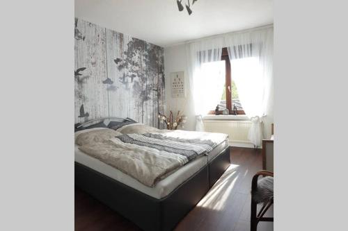a bedroom with a bed and a window at An den Auwiesen in Kleineicholzheim