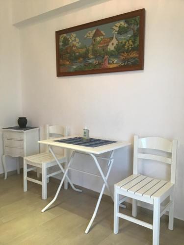 a table and two chairs and a table and a painting at Villa Maria in Kamariotissa