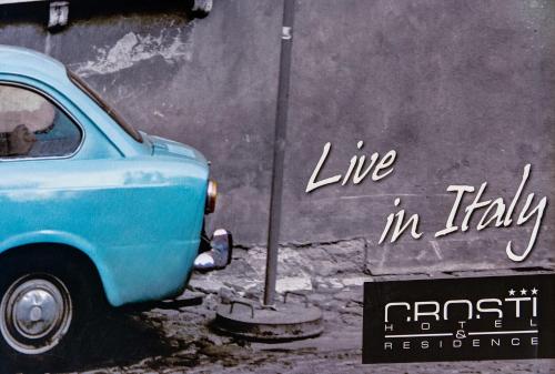 a blue car parked next to a wall at Crosti Hotel in Rome