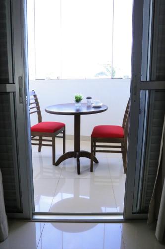 a table and two chairs and a table and a window at Tezla Hotel in Primavera do Leste