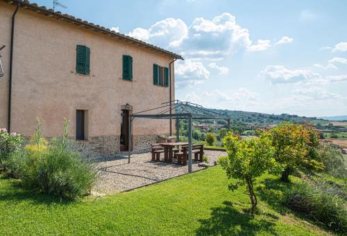 a building with a picnic table in a yard at Casolare Marconi in Panicale