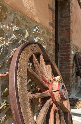 a wooden wagon wheel sitting next to a brick building at Casolare Marconi in Panicale