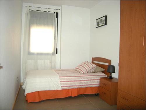 Apartamentos Los Mayos de Albarracín في بني الرزين: غرفة نوم بسرير ونافذة