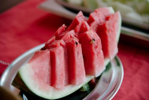 a slice of watermelon on a plate on a table at Pousada Altamira in Ilhabela