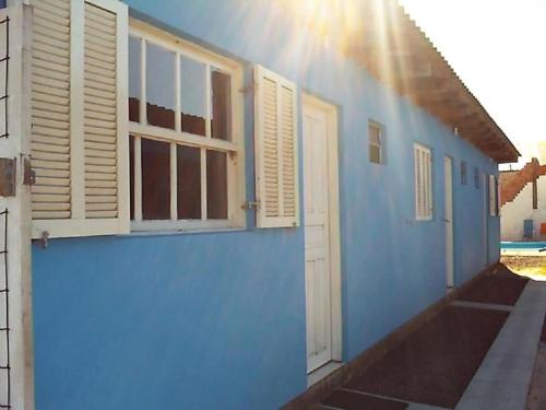 a blue building with whitewindows and a blue wall at Residencial Água Azul in Capão da Canoa