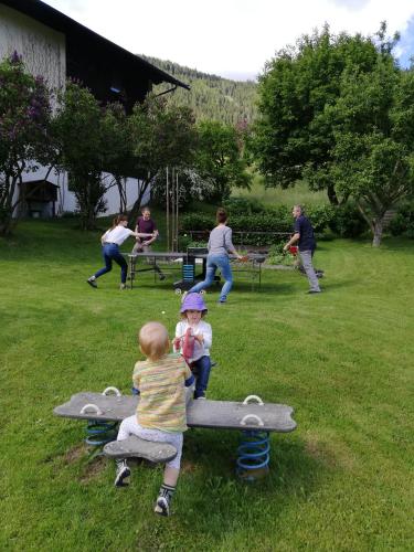 two children are playing on a bench in a park at Pension & Ferienwohnung Sonnleiten in Gnesau