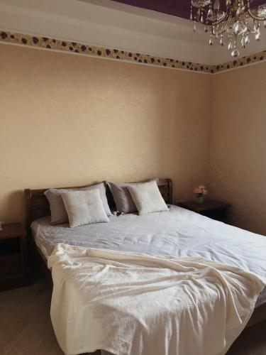 a bedroom with a bed with white sheets and pillows at Kuchonka in Chornomorsk