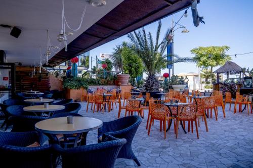 um grupo de mesas e cadeiras num restaurante em Hotel Giorgetti Orange em Bellaria-Igea Marina