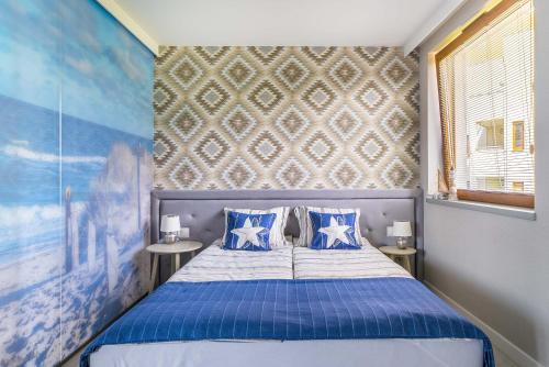 a bedroom with a blue bed with blue pillows at Surf Apart in Władysławowo