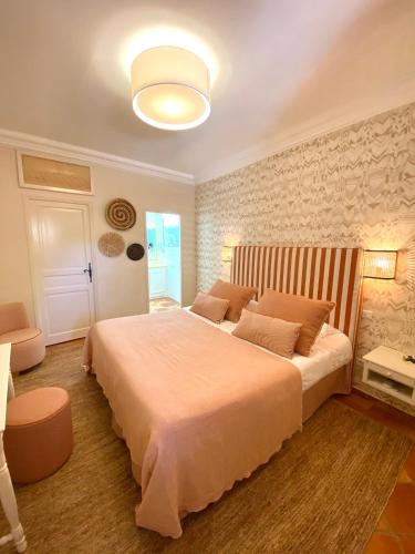une chambre avec un grand lit dans une pièce dans l'établissement La Bastide Du Port - Hôtel de Charme, à Saint-Tropez