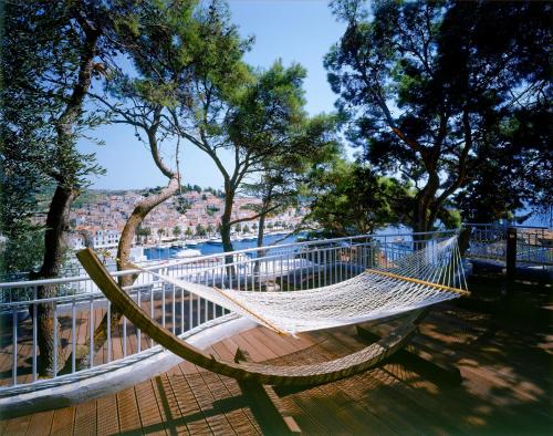 a hammock on a deck with a view of the city at Adriana Hvar Spa Hotel in Hvar