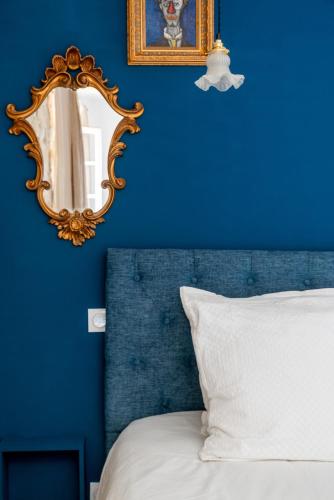 a blue bedroom with a mirror and a bed at DODO etc in Nyons