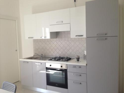 a white kitchen with a stove and a refrigerator at Marconi’ home in Margherita di Savoia