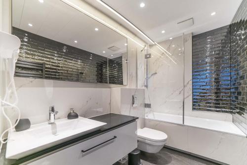 a bathroom with a sink and a toilet and a tub at Surf Apart in Władysławowo