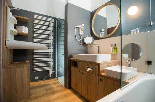 La salle de bains est pourvue d'un lavabo et d'un miroir. dans l'établissement Hotel Sonnenpark & Therme included - auch am An- & Abreisetag!, à Lutzmannsburg