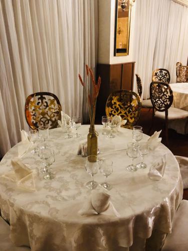 a table with wine glasses and a vase on it at Hotel Plaza in Craiova