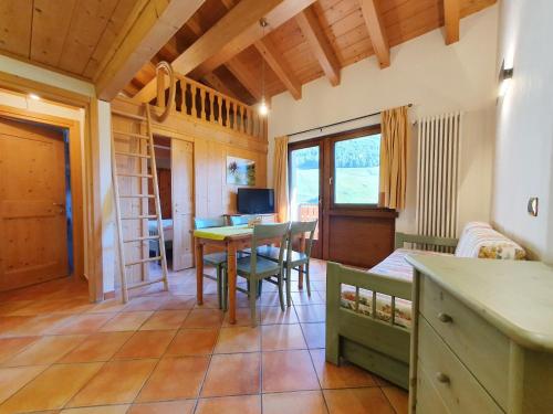 eine Küche und ein Wohnzimmer mit einem Tisch und Stühlen in der Unterkunft Residence Bait da Mott in Livigno