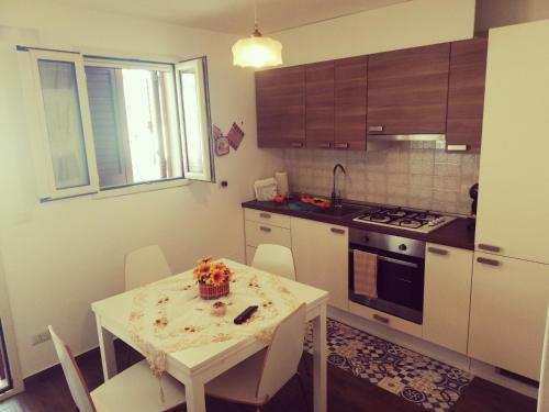 モーラ・ディ・バーリにあるAppartamento PANTA REI 2のキッチン(白いテーブル、テーブル、椅子付)