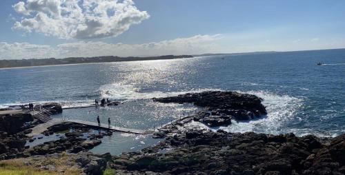a group of people standing on a pier in the ocean at Oceanview Kiama Luxury Holiday Accommodation in Kiama