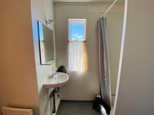 baño con lavabo y ventana en Ábót - Riverside Cottage, en Egilsstadir