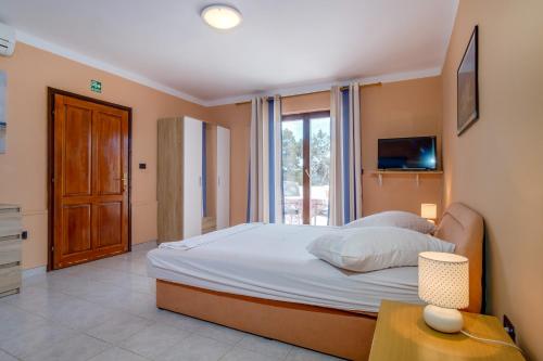 a bedroom with a large bed and a window at Apartments Villa Julija in Mali Lošinj