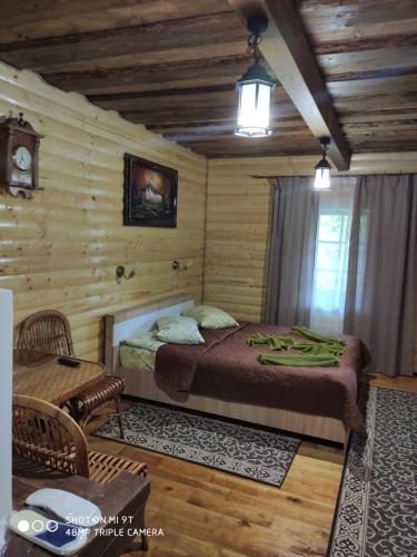 une chambre avec un lit dans une cabane en rondins dans l'établissement Smerekova Hata, à Slavsko