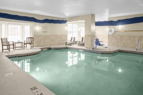 a pool in a hotel with chairs and a table at Staybridge Suites Chattanooga-Hamilton Place by IHG in Chattanooga