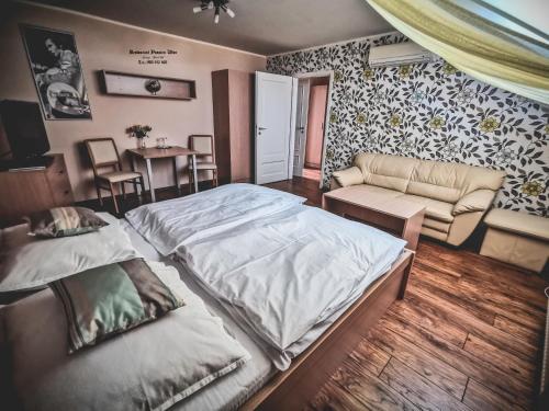 a bedroom with two beds and a couch and a table at Restaurant Pansion Wien in Čierny Brod