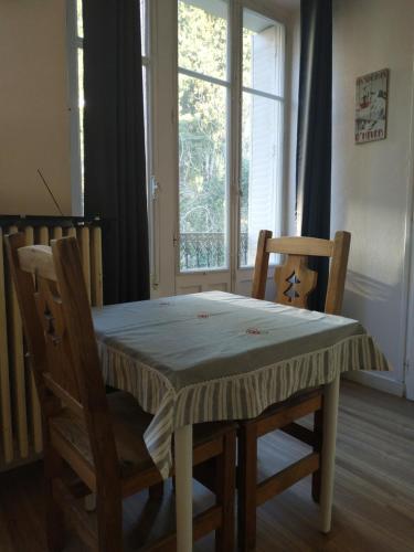 d'une table, de chaises et d'une fenêtre. dans l'établissement Joli studio calme parking proche thermes et centre, à Aix-les-Bains