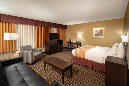 a hotel room with a bed and a couch at Quality Inn & Suites Windsor - Downtown in Windsor
