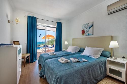 a bedroom with a bed with a view of the ocean at Forte São João Villas da Praia in Albufeira