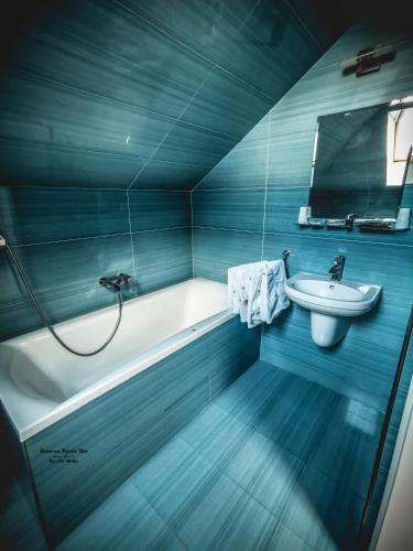 a blue bathroom with a tub and a sink at Restaurant Pansion Wien in Čierny Brod