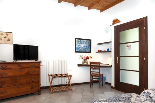 a bedroom with a dresser and a desk with a television at Cascina Scanna in Cisliano