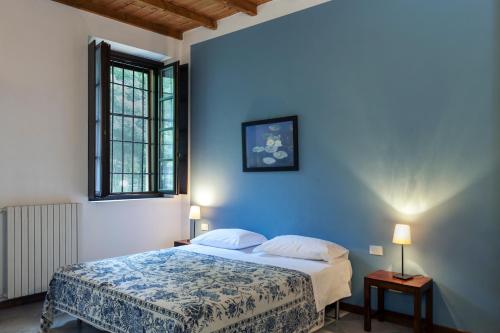a blue bedroom with a bed and a window at Cascina Scanna in Cisliano