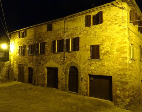 an old stone building at night with a street light at Lucignolo in Lucignano