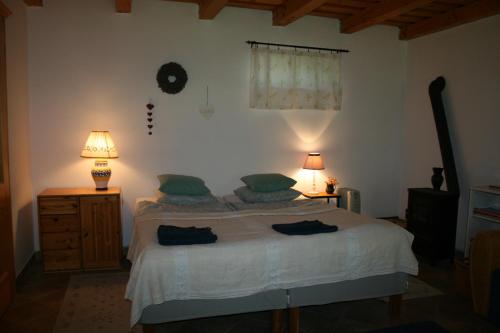 sypialnia z łóżkiem i 2 lampami oraz zegarem na ścianie w obiekcie Héregi Éden Vendégház w mieście Héreg