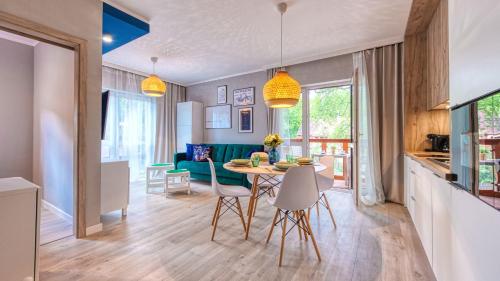 a kitchen and living room with a table and chairs at Apartamenty Holiday Mountain Residence by Royal Aparts in Świeradów-Zdrój